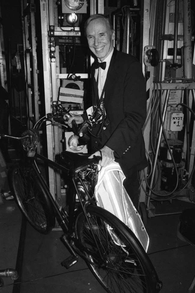 Outtake; Bill Cunningham posing with his award for achievements in fashion journalism and his trademark bicycle during the CFDA fashion awards at Lincoln Center on February 8, 1994 in New York. Article title: "Suzy: On the CFDA"