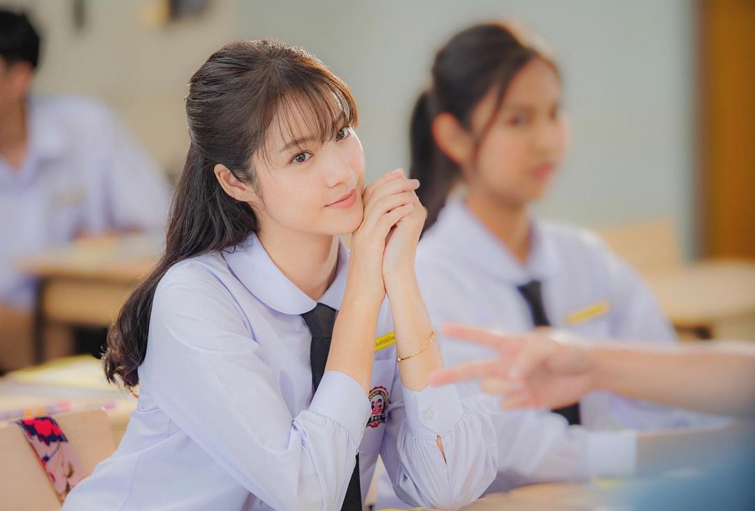 Namtan穿著合身背心與寬鬆牛仔褲，展現率性俐落風格。