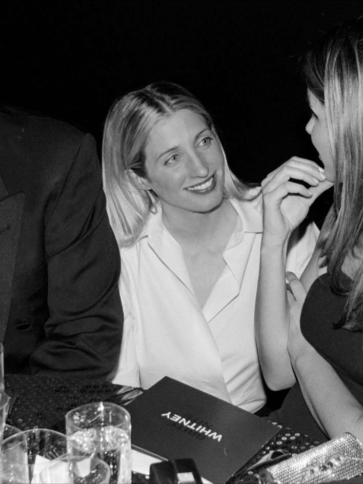 金髮女性身穿剪裁俐落的黑色長裙，展現九○年代極簡風格。