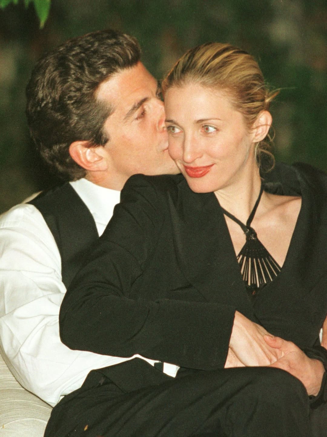 金髮女性穿著黑色俐落大衣與白襯衫,展現極簡冷靜風格。